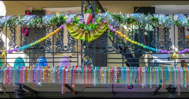 mardi gras beads on a balcony and carnival ornaments on a balcony in a street of the french quarter, new orleans, louisiana mardi gras beads on a balcony and carnival ornaments on a balcony in a street of the french quarter, new orleans, louisiana